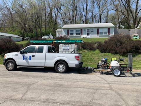 A Royal Blue Power Washing commercial truck hauling professional power washing equipment to a residential home for concrete cleaning services in Kansas City, MO.