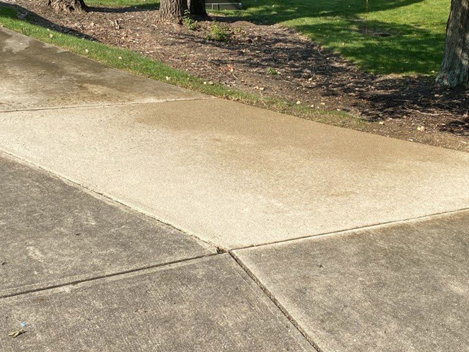 Driveway with one section cleaned by Royal Blue Power Washing in Kansas City, MO