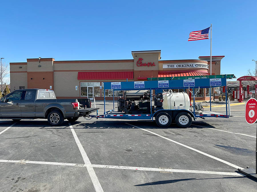 royal blue power washing truck and trailer parked in a chick-fil-a parking lot in kansas city mo.