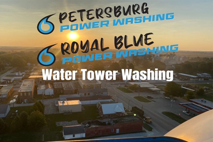 Picture of a sunset on a lift next to the top of a water tower overlooking the city of Roseville, IL. The Petersburg Power Washing and Royal Blue Power Washing logos are placed on the picture with the words “Water Tower Washing” in white letters underneath.